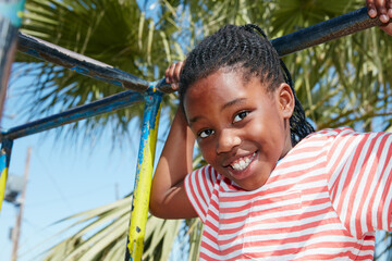 Child, smile and portrait on jungle gym at school for playing, recess or motor skills development....