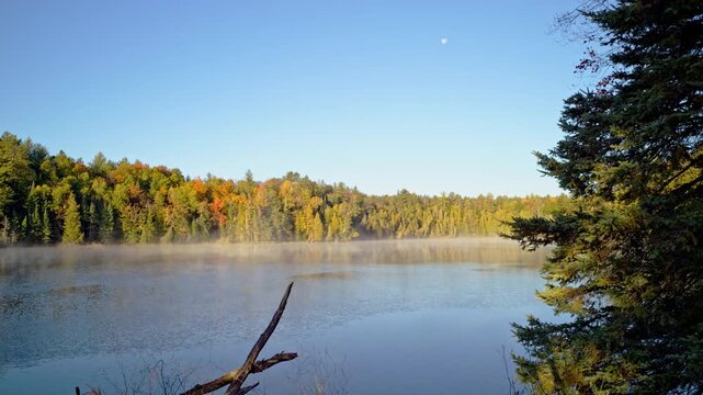 Cinematic atmospheric shot of fog hovering above the Au Sable River.