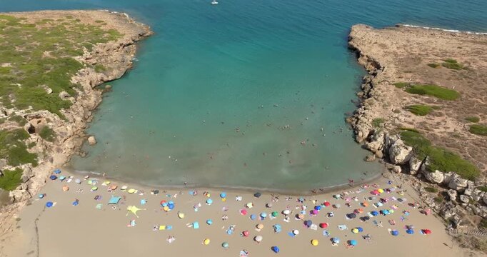 Aerial view of Cala Mosche (or Calamosche) beach, a beautiful sandy beach within the Vendicari Nature Reserve, near Noto, Sicily, Italy. It's famous for its crystal clear and blue waters. Sunny day.