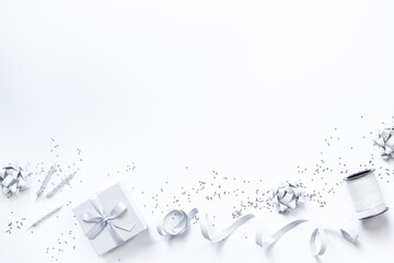 Festive party decoration in silver color with gift box and carnaval caps on white background, top...