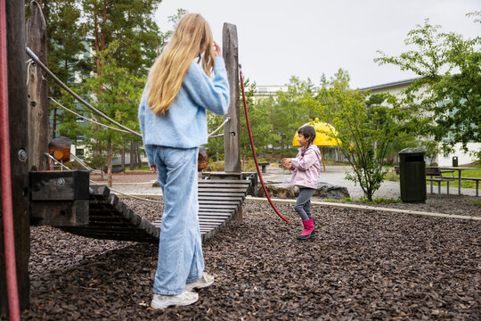 Siblings spending leisure time playing together at jungle gym