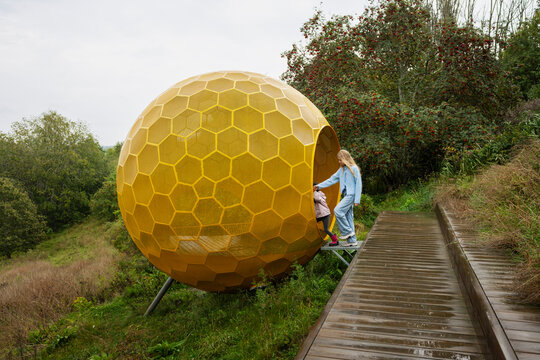 Siblings entering in yellow colored sphere with honeycomb pattern