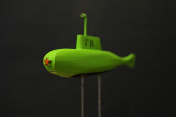 green submarine slowly moving underwater