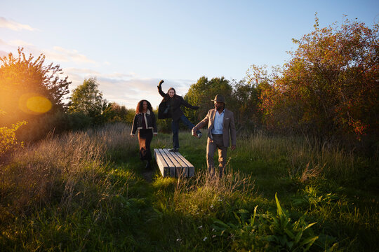 Carefree friends spending leisure time walking amidst plants at park