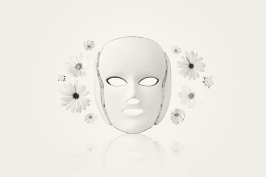 Demonstrating the colors of 2026 - Cloud Dancer. Cosmetic LED facial mask regenerative treatment with flowers cosmos, asters, and dahlias. Health and beauty of the face.