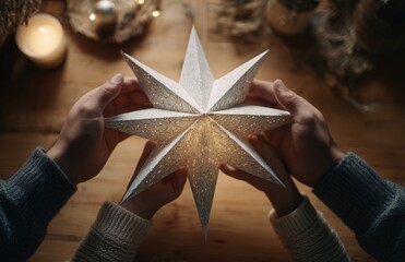 Family hands holding glowing paper star decoration