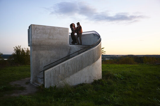 Male and female friends dancing while standing near steps