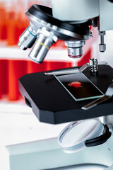 close up macro microscope with blood sample, tubes on white background. Laboratory working place 