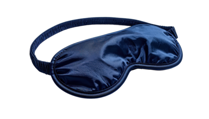 Close-up of a dark blue, satin sleep mask with elastic strap on a black background