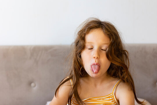 Girl with eyes closed sticking out tongue