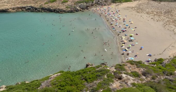 Aerial view of a beautiful cove with a sandy beach. It is Cala Mosche (or Calamosche) beach, a beautiful golden sandy beach within the Vendicari Nature Reserve, in province of Syracuse, Sicily, Italy.