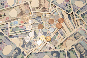 Full frame, detailed close-up of scattered Japanese Yen banknotes and coins. Concept of wealth, inflation, exchange and world finance.