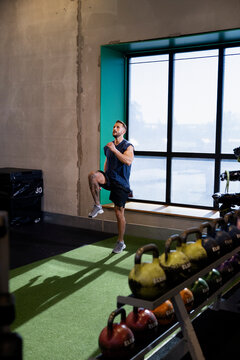 Active man doing high knee exercise in gym