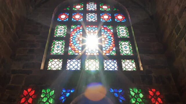 Colorful stained glass window with sunlight shining through