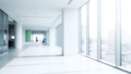 Bright empty hospital corridor with blurred figures in the distance