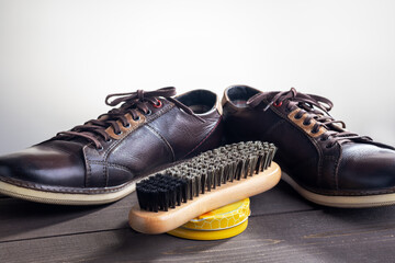 Shoe care products and footwear on dark wooden table.