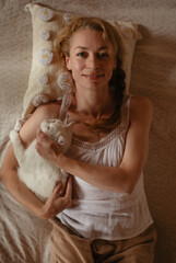 Portrait of a girl on a bed with a white cat