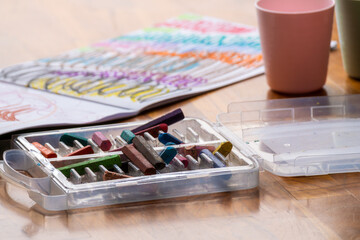 colorful crayons and drawing book on wooden table for childrens art and learning activities