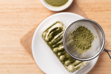 Matcha Tiramisu cake with green tea powder on top, Italian dessert fusion with Japanese, Top view