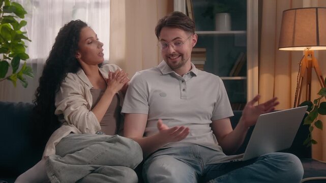 Multiracial couple family Caucasian man Hispanic Latina woman talking shopping discussion looking at laptop at home online shop store buying girlfriend wife husband male checking pc screen together
