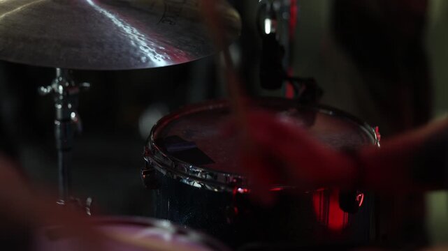 Intimate shot capturing rhythmic drumming with dazzling reflections
