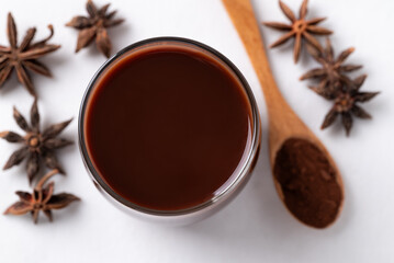 Hot chocolate in glass and star anise on white background, Top view