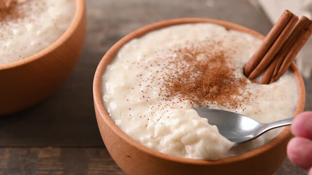 Eating rice pudding on wooden bowl on wooden table