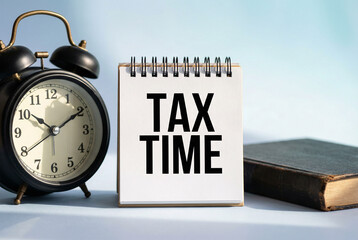 Tax time reminder with alarm clock and planner on wooden desk, finance deadline, payment and accounting concept.