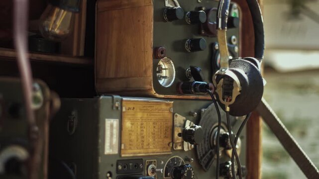 Detail shot of vintage Soviet field radio station equipment with numerous dials, knobs, and attached headphones, part of Red Army display during Great Patriotic War historical exhibition