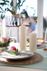 Wedding table decorated with pink roses. Festive set table for a wedding dinner. Bright, elegant restaurant background. Vertical close-up with short depth of field.
