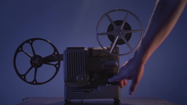 A classic 8mm film projector shines a diffused warm beam through dusty air, evoking the charm of old cinema nights and nostalgic film projection in an intimate retro setting.