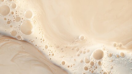 Close up of creamy beige liquid surface with many bubbles. Abstract fluid texture. Background for cosmetic, food, or beverage product.