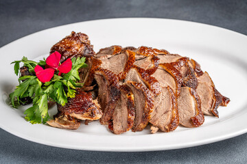 Roasted duck slices on white plate