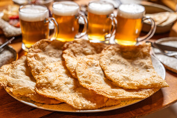 Crispy chebureki with beer in warm dining setting