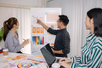 UX/UI designers collaborating during a creative workshop to test interface ideas and exchange feedback for app development, emphasizing teamwork and innovative design thinking.