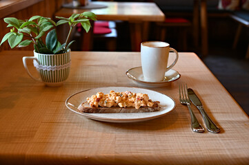 delicious traditional rustic Bavarian cheese called Obazda on the piece of the rustic bread wooden table at an alpine cafe in the Bavarian Alps	