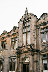 Fototapeta premium Ornate Historic Stone Building Facade with Arched Entrance and Tall Windows