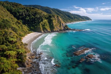 Obraz premium Aerial view of a secluded coastal cove with lush vegetation, a sandy beach, and turquoise waters