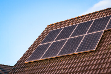 Solar panels on roof. Clean energy, green energy, sustainable, eco-friendly technology powered by the sun. Renewable energy solutions building house with roof tiles close up.