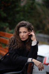 Fototapeta premium Woman sitting outdoors with curly hair