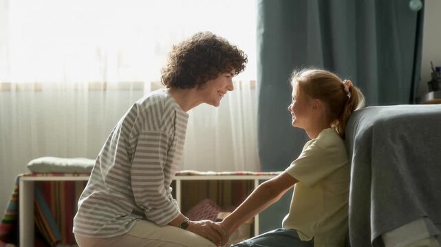 Side view of cheerful girl child holding hands with supportive mother during warm conversation while sitting in bedroom, AI generative shot