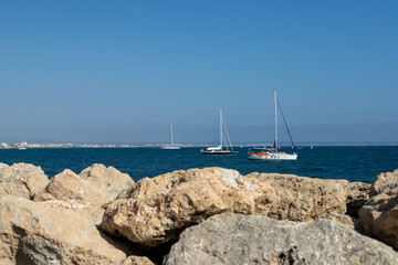Sailboats on the Mediterranean Sea with Coastal Rocks in Foreground