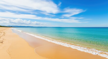 Fototapeta premium Sandy beach meets calm turquoise ocean waters under a bright blue sky with white clouds. Perfect for travel promotions, vacation themes, coastal getaways, and summer relaxation content.