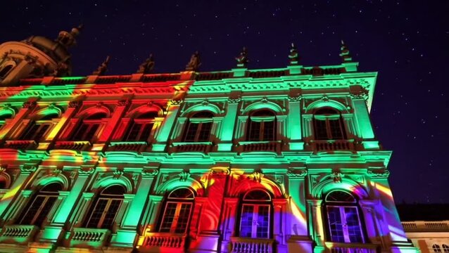 Carnival mapping projection on historic Rio building at night.
