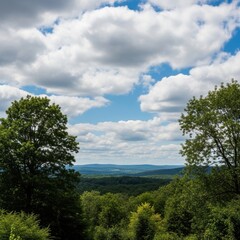 Obraz premium Idyllic landscape vista with scattered fluffy clouds above a verdant mountainous expanse on a