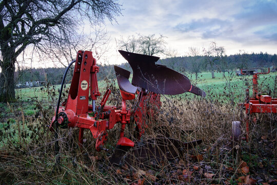 Ein Drehpflug der Marke Volly-Mat abgestellt und zugewachsen mit Gestr&uuml;pp am Rande eines Ackers
