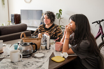 Mother and daughter are sitting at a table, one of them is wearing a striped shirt