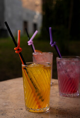 Colorful Cocktails in Glasses with Straws on the Table