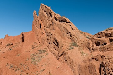 Fototapeta premium Fairytale Canyon (Canyon Skazka) was formed by the erosion of multi colored clays, rocks and minerals. It is located near the southern shore of Issyk Kul Lake in Kyrgyzstan. Asia.