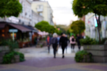Fototapeta premium Abstract blurred background. A group of people is walking down the street.